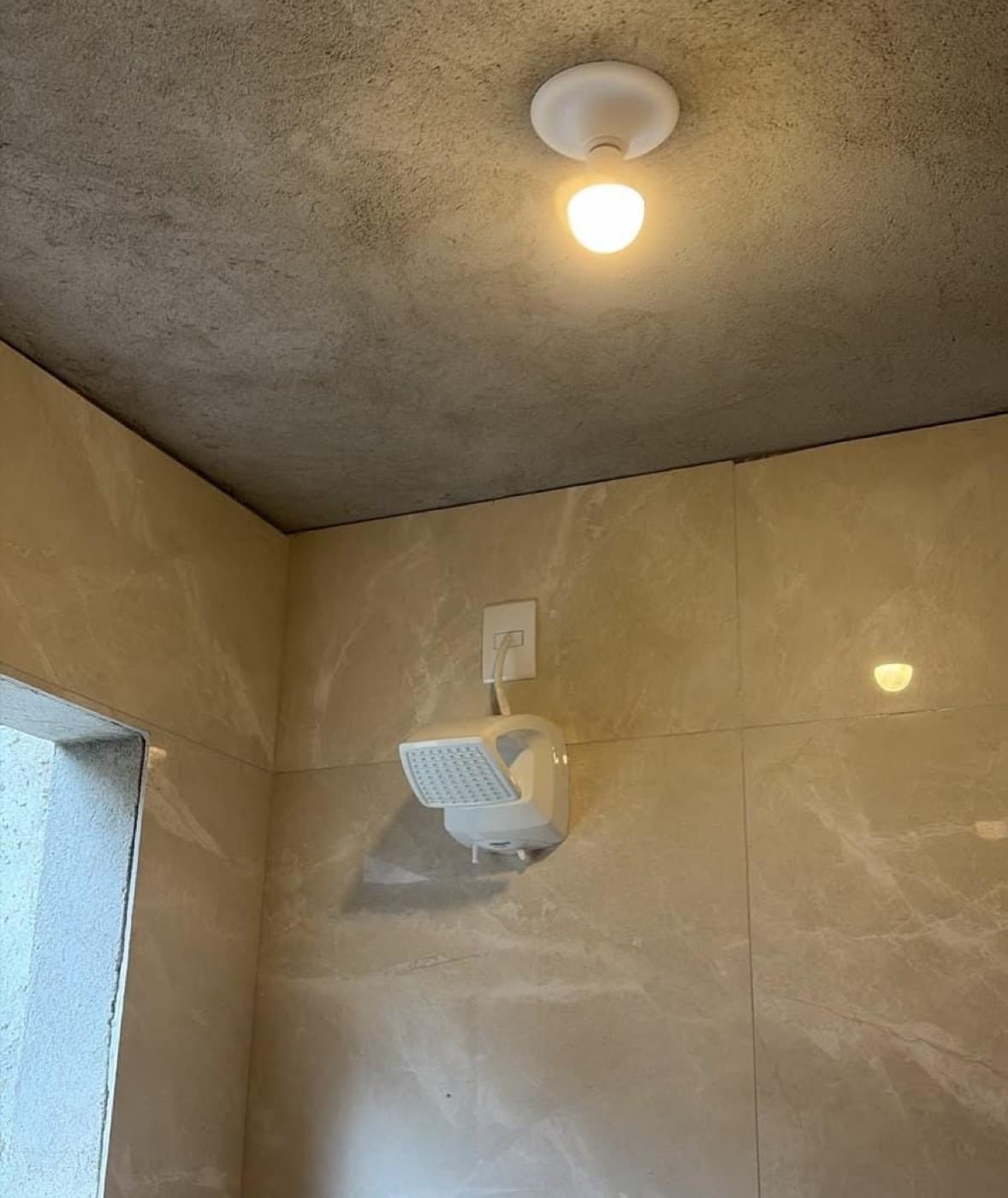 Chuveiro elétrico instalado pela PG em banheiro com porcelanato